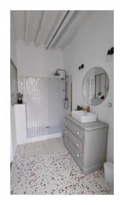 Baño blanco con lavabo y espejo en Maison Charmeilles - La suite Pomerol en Fronsac