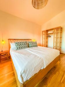 - une chambre avec un grand lit et des draps blancs dans l'établissement Sunset Club - Nesselwang Chalets Nr 2, à Nesselwang
