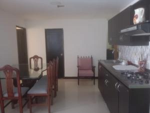 a kitchen with a stove and a table and chairs at casa 4 cocorna in Cocorná