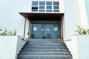 una escalera que conduce a un edificio con puerta de cristal en HOTEL ACHYUT, en Tirupur