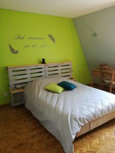 ein Schlafzimmer mit einem Bett mit einer grünen Wand in der Unterkunft "Côté cœur", charmant appartement au centre de Munster in Munster