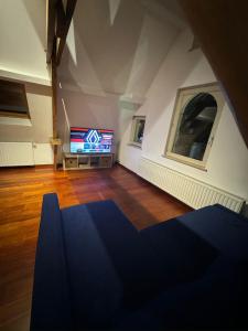 d'un salon avec une télévision dans l'angle d'une pièce. dans l'établissement Elegant Grand Place Stays, à Bruxelles