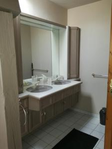 ein Badezimmer mit zwei Waschbecken und einem großen Spiegel in der Unterkunft "Côté cœur", charmant appartement au centre de Munster in Munster
