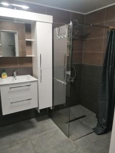 W łazience znajduje się szklana kabina prysznicowa i umywalka. w obiekcie Bright Rooms w Krakowie