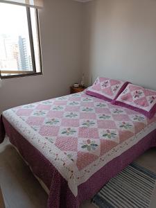 eine rosa Decke auf einem Bett im Schlafzimmer in der Unterkunft Haumaru Alojamiento habitación privada in Santiago