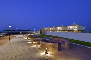 a patio with a fire pit and lights next to a building at The Fern Leo Beach Resort , Madhavpur in Porbandar