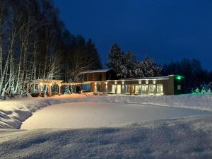 una casa cubierta de nieve por la noche en RELAX VILLA 