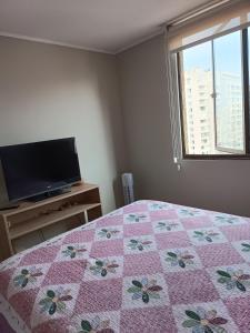 una camera con un letto con una trapunta sopra di Haumaru Alojamiento habitación privada a Santiago