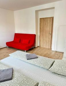 a living room with a red couch and a bed at Centrum apartment in Brno