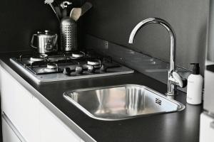 a kitchen counter with a sink and a stove at De Viool Appartementen in Buren