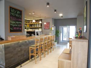 um restaurante com um bar com bancos de madeira em EA Business Hotel Jihlava em Jihlava