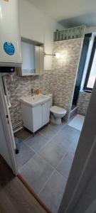 a bathroom with a tub and a toilet and a sink at Logement centre ville wifi in Voiron