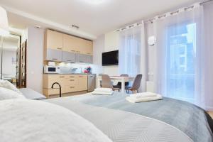 sypialnia z 2 łóżkami i kuchnia ze stołem w obiekcie Apartamenty Świnoujście - Bałtycka w Świnoujściu