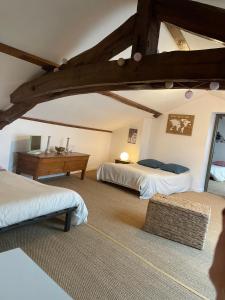 a bedroom with two beds and a desk in a room at Chambre d'Hôtes La Cour des Saligues in Riscle