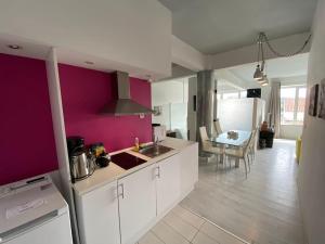 a kitchen with white cabinets and a purple wall at COMBO Acropolis view 6 bedrooms 4 bathrooms in Athens