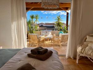 een slaapkamer met een bed en een tafel en stoelen bij Au Bonheur Dezange in Pézenas