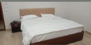 una camera da letto con un grande letto con lenzuola e cuscini bianchi di Hotel Amrapali Inn Jaipur a Jaipur