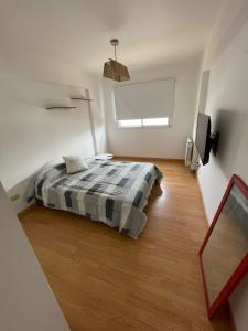 1 dormitorio con 1 cama y TV en Art Plants Apartment en Mar del Plata