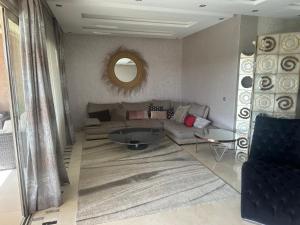 a living room with a couch and a mirror at Appartement golf prestigia in Marrakesh