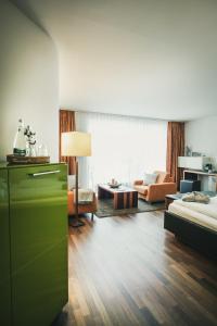 sala de estar con cómoda verde y sofá en Hotel Lauterbad, en Freudenstadt