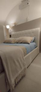 1 cama con cabecero blanco en una habitación en Itinerario Barocco, en Ragusa