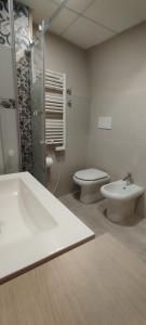 a bathroom with a sink and a toilet and a shower at Itinerario Barocco Apartment Ragusa Ibla - Eleganza e Comfort nel Cuore del Barocco Siciliano in Ragusa +12 photos