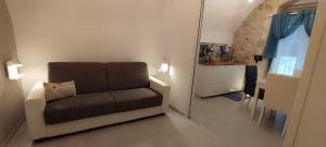 a living room with a couch and a window at Itinerario Barocco Apartment Ragusa Ibla - Eleganza e Comfort nel Cuore del Barocco Siciliano in Ragusa