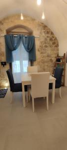 a dining room with a table and chairs and a window at Itinerario Barocco in Ragusa