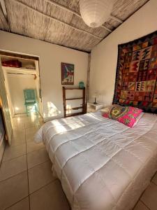 a bedroom with a large white bed in a room at Eco-Hostel Lo de Lola in San Fernando del Valle de Catamarca