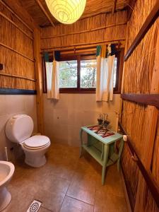 a bathroom with a toilet and a table with a sink at Eco-Hostel Lo de Lola in San Fernando del Valle de Catamarca