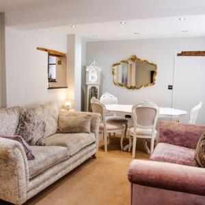 a living room with a couch and a table and a mirror at Whispering Place in the heart of Bewdley in Bewdley