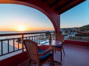 PORTO-FINO في أريلاز: شرفة مع طاولة وكراسي وإطلالة على المحيط
