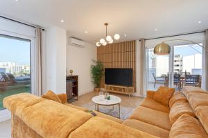 贝纳尔马德纳Luxury Penthouse Sea Views- Jacuzzi - Sauna的客厅配有棕色沙发和电视
