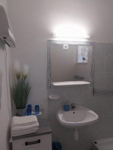 Baño blanco con lavabo y espejo en Repi-Tár apartman, en Szolnok