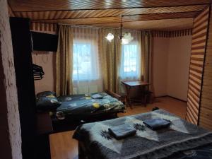 a bedroom with two beds and a desk in it at V Ulyanu in Yaremche