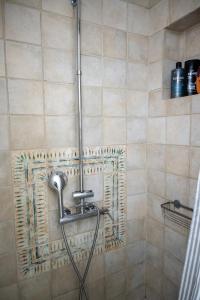 a shower with a hose in a bathroom at Μονοκατοικία με κήπο στη θάλασσα. in Korinthos