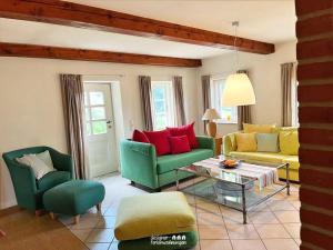 a living room with green and yellow chairs and a table at Reetdach-Oase in Brarupholz