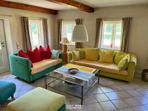 a living room with two couches and a table at Reetdach-Oase in Brarupholz