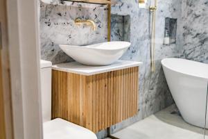 a bathroom with a white bowl sink on a wooden stand at Benyon Street Townhouse in Shrewsbury