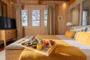 une chambre d'hôtel avec un plateau de nourriture sur un lit dans l'établissement Hôtel Côté Sable, à Cap-Ferret