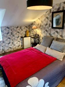 a bedroom with a large bed with a red blanket at La Passerelle in Loguivy-Plougras