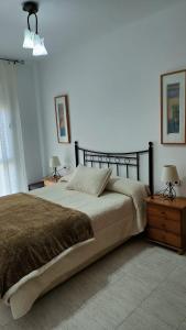 1 dormitorio con 1 cama grande y 2 mesitas de noche en Apartamentos Montsià Mar, en Sant Carles de la Ràpita