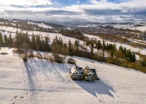 uma vista aérea de duas casas na neve em Cichy Brzyzek em Biały Dunajec