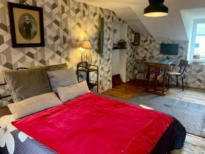 a bedroom with a large bed with a red blanket at La Passerelle in Loguivy-Plougras