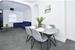a dining room with a table and a blue couch at Townhouse @ 20 Penkhull New Road Stoke in Stoke on Trent