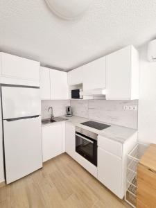 a white kitchen with white appliances and white cabinets at Elizabeta - Playa Mil Palmeras in Campoamor