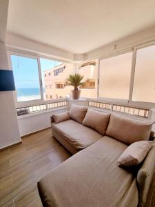 a large living room with a couch and windows at Elizabeta - Playa Mil Palmeras in Campoamor