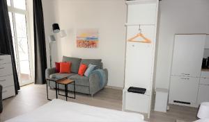 uma sala de estar com um sofá cinzento e almofadas laranja em Villa Azur em Sassnitz