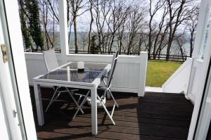 uma mesa de vidro e 2 cadeiras numa varanda em Villa Azur em Sassnitz