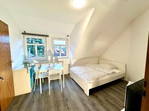 ein kleines Schlafzimmer mit einem Bett und einem Tisch in der Unterkunft Monteur-Zimmervermietung Visselhövede in Visselhövede
